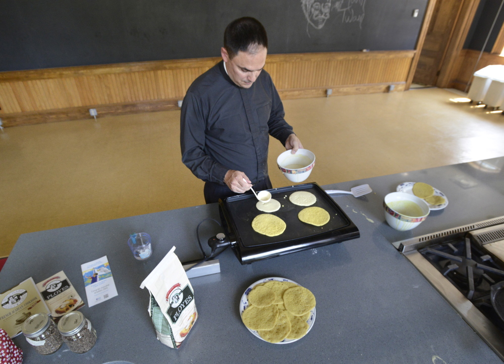 Father Paul Dumais makes ployes in a kitchen at St. Mary's Nutritional Center in Lewiston.
John Patriquin/Staff Photographer