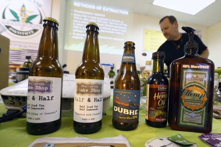 Mike Fitzgerald, right, teaches behind a sample display of cannabis-infused products during a cooking class at the New England Grass Roots Institute in Quincy, Mass.