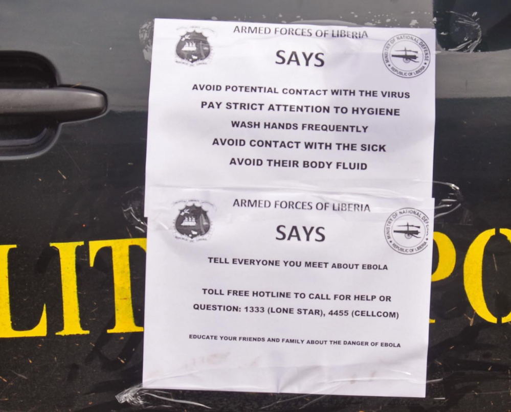 A Liberian military police truck with Eboal warnings on its door, one reading ‘Tell Everyone You Meet About Ebola.’