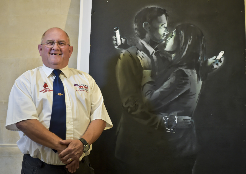 Dennis Stinchcombe poses with “Mobile Lovers,” which fetched $668,000 for a British youth group.