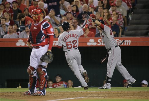 Red Sox outfielder Yoenis Cespedes is greeted by Will Middlebrooks after scoring on a sacrifice fly by Xander Bogaerts as Los Angeles Angels catcher Hank Conger looks on in the seventh inning Aug. 10. The Associated Press