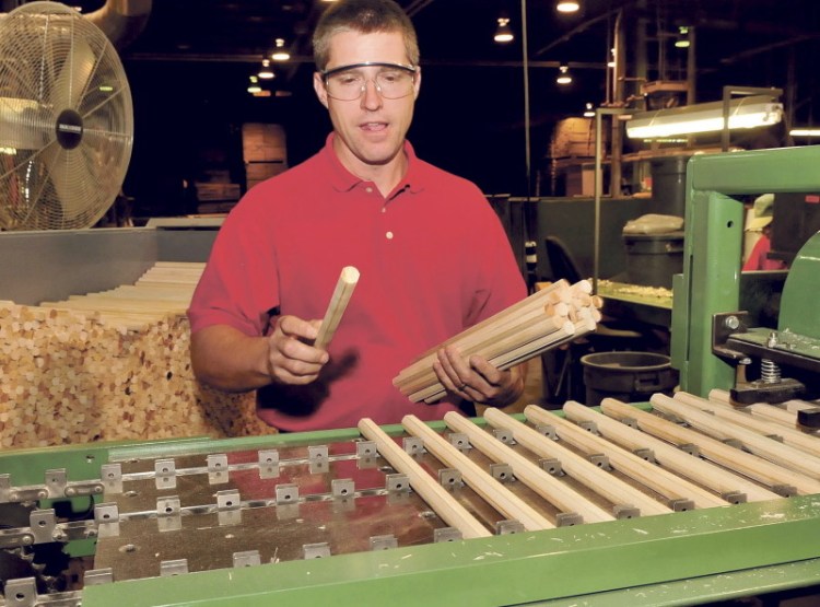 Pride Manufacturing company employee John Nelson places dowels on a machine that will mill them into Lincoln Log pieces at the Burnham company on Wednesday.