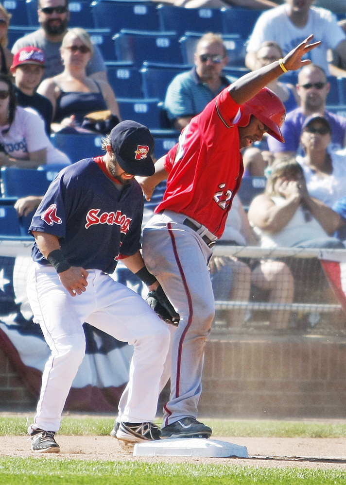 Harrisburg’s Quincy Latimore, right, holds his spot on third base as Portland’s Mike Miller applies a late tag during the Senators’ 3-0 win Monday at Hadlock Field in Portland.