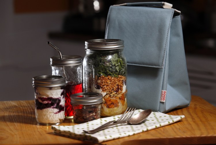 A lunch of salad, yogurt and other snacks, all packed in Mason jars, with a cloth napkin and real silverware means no plastic or paper waste.