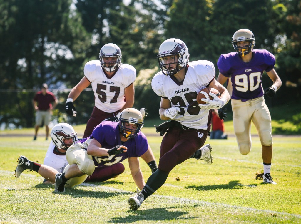 Windham running back Dylan Koza finds plenty of room as he races away from Cheverus defenders Zach Handley, left, and Zordan Holman during their Eastern Class A football showdown Saturday at Boulos Stadium. Koza rushed for 125 yards and two touchdowns, and Windham rolled to a 35-7 victory. Whitney Hayward/Staff Photographer