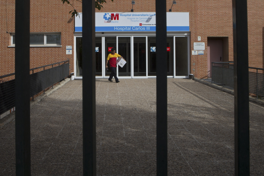 A worker makes a delivery at the entrance of the Carlos III  hospital in Madrid, Spain, Tuesday where a Spanish nurse who is believed to have contracted the Ebola virus from a 69-year-old Spanish priest is being treated after testing positive for the virus.