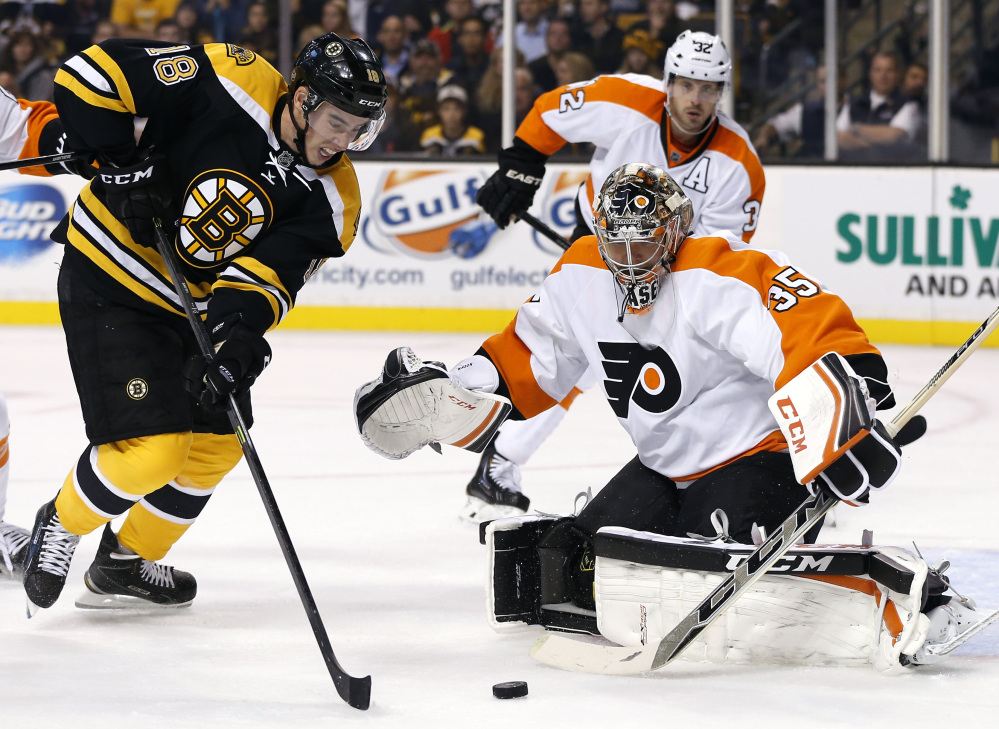 Reilly Smith of the Bruins shoots but misses as Flyers goalie Steve Mason protects the net in the second period Wednesday night at Boston. The Bruins scored a late goal for a 2-1 win to open the season.