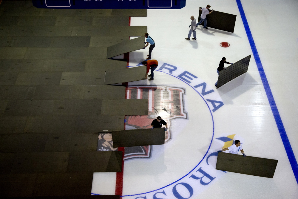 Workers remove floorboards at the Cross Insurance Arena to prepare the ice fora game. It's unclear whether Portland will get an ECHL team for the 2017-18 season.