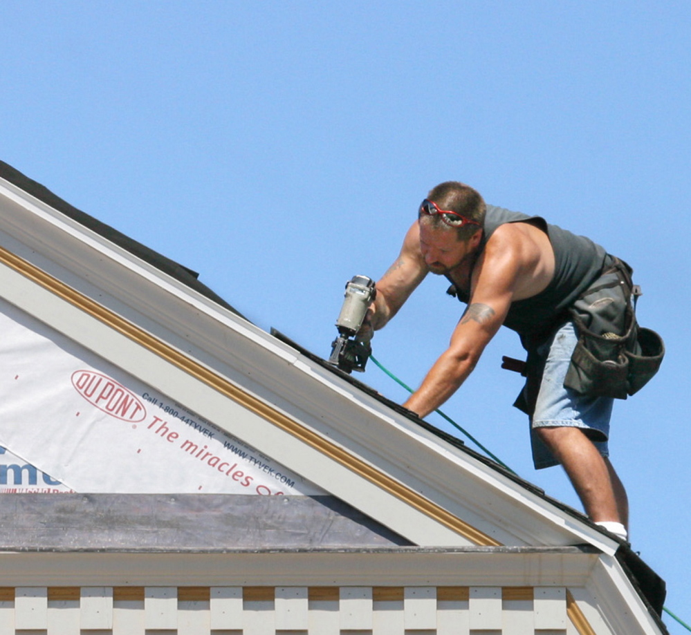 Staff photo by Gregory Rec -- Friday, July 16, 2004 -- Rich Britton shingles a roof of a home under construction in the Cape Neddick section of York. The town has what some consider the most restrictive zoning in the state, and there is a two to three year wait to get a permit to build a new home.