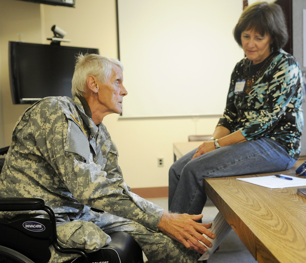 Murray Decker of Saco, at left, speaks on Saturday with Maine Department of Labor CareerCenter employee Auta Main during the 17th Maine Homeless Veterans Stand Down. 