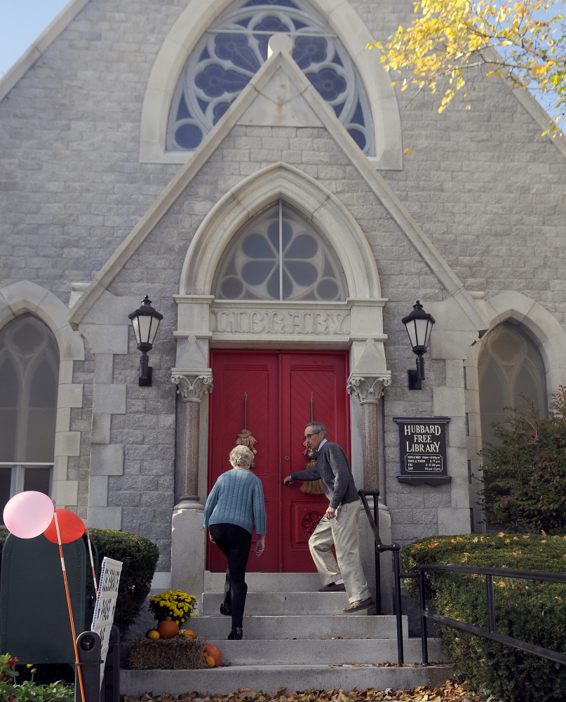 Sumner Webber opens the door for his wife, Cathy, on Sunday at the Hubbard Free Library in Hallowell. Library members celebrated completing the first phase of restoring the library while preparing to raise funds to continue repairs on the 19th century structure.