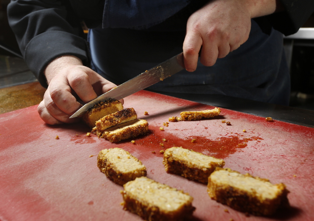 Grace chef Adam Flood slices tempeh.