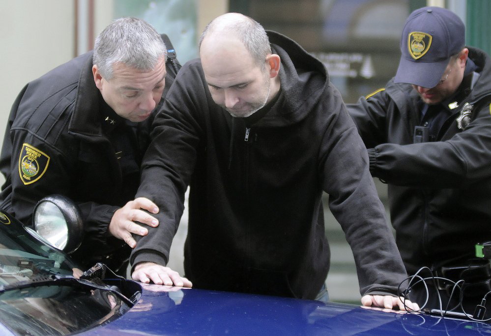 Gardiner Police Chief James Toman, left, and Patrolman Norm Gove arrest Jason Beckwith of Pittston on Wednesday on Water Street.