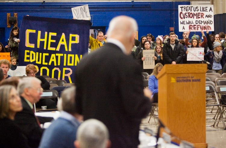 University of Southern Maine President David T. Flanagan, center, addresses student protesters who walked into a trustees meeting to voice their dissatisfaction with recent cuts in programs.