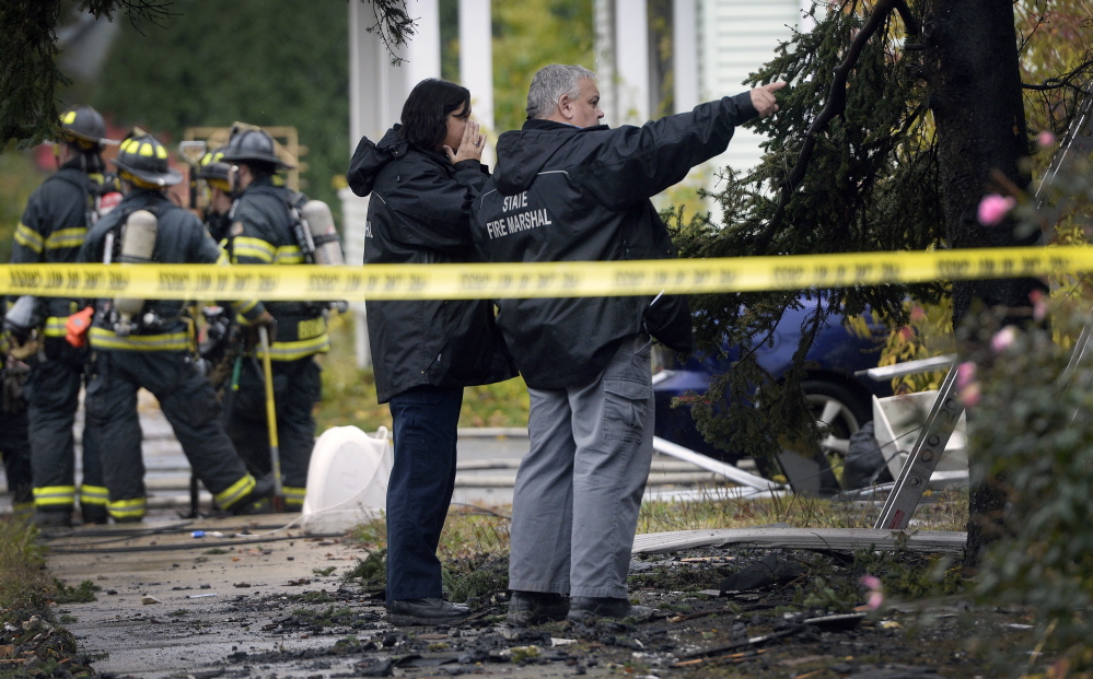 State fire marshals examine the apartment building where five people died in a fire Saturday. Neighbors say they had on occasion complained to the city about the property’s condition.