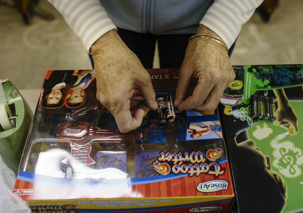 Jody Abbott tapes batteries to toys in Freeport.