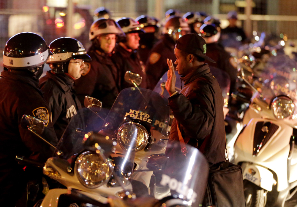 A protester stands in front of a line of police officers during a protest Wednesday night in New York after a grand jury decided not to indict a New York police officer who was involved in the death of an unarmed black man.