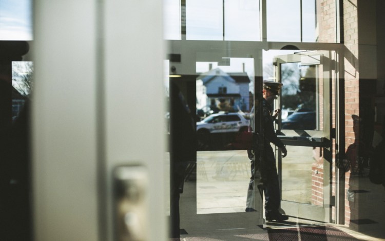 A Saco police officer enters Thornton Academy on Thursday, before a press conference about threats directed at the school this week.