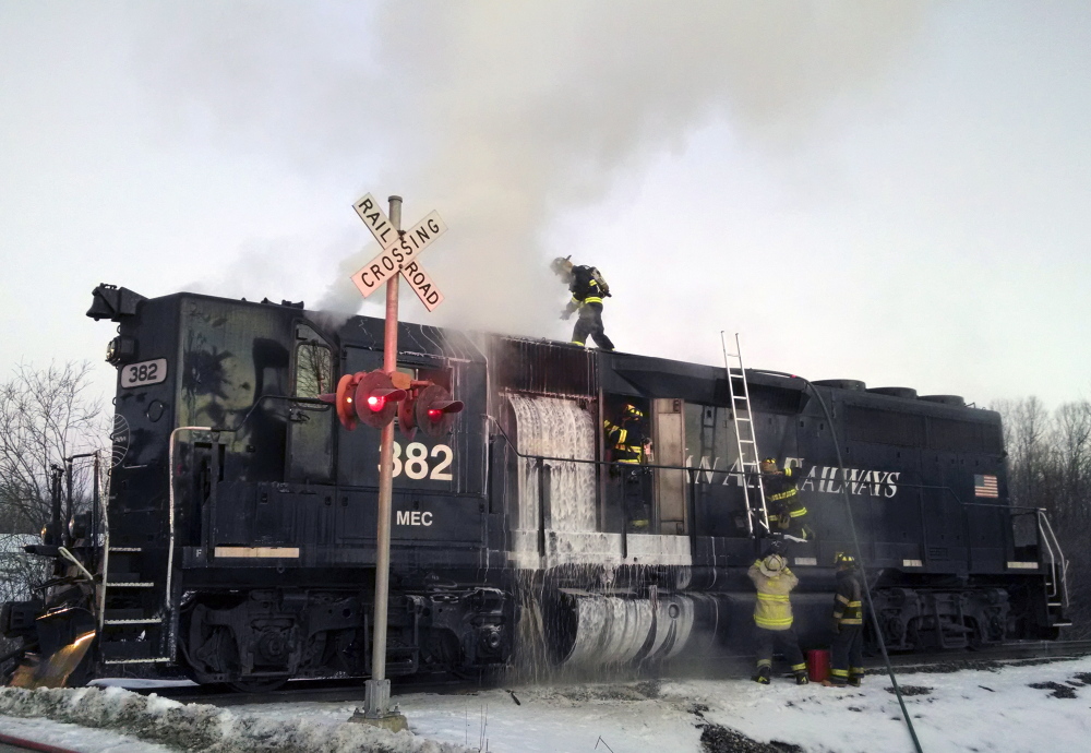 Monmouth firefighters work to extinguish a locomotive fire on a Pan Am Railways train Saturday morning near Berry Road in Monmouth.