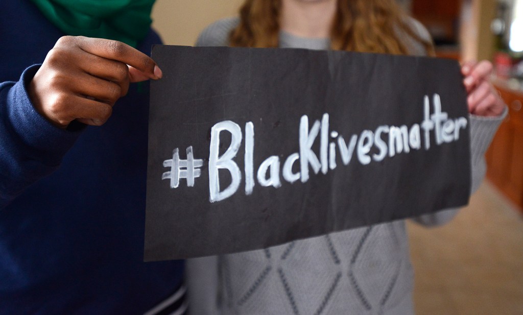 Senior Muna Mohamed and junior Chandler Clothier hold part of the poster that a group of Lewiston High School students was asked to take down.
