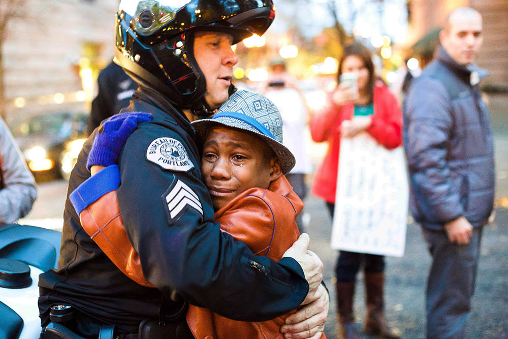Police Sgt. Bret Barnum and Devonte Hart, 12, hug at a rally in Portland, Ore., where people had gathered in support of the protests in Ferguson, Mo., on Nov. 25.