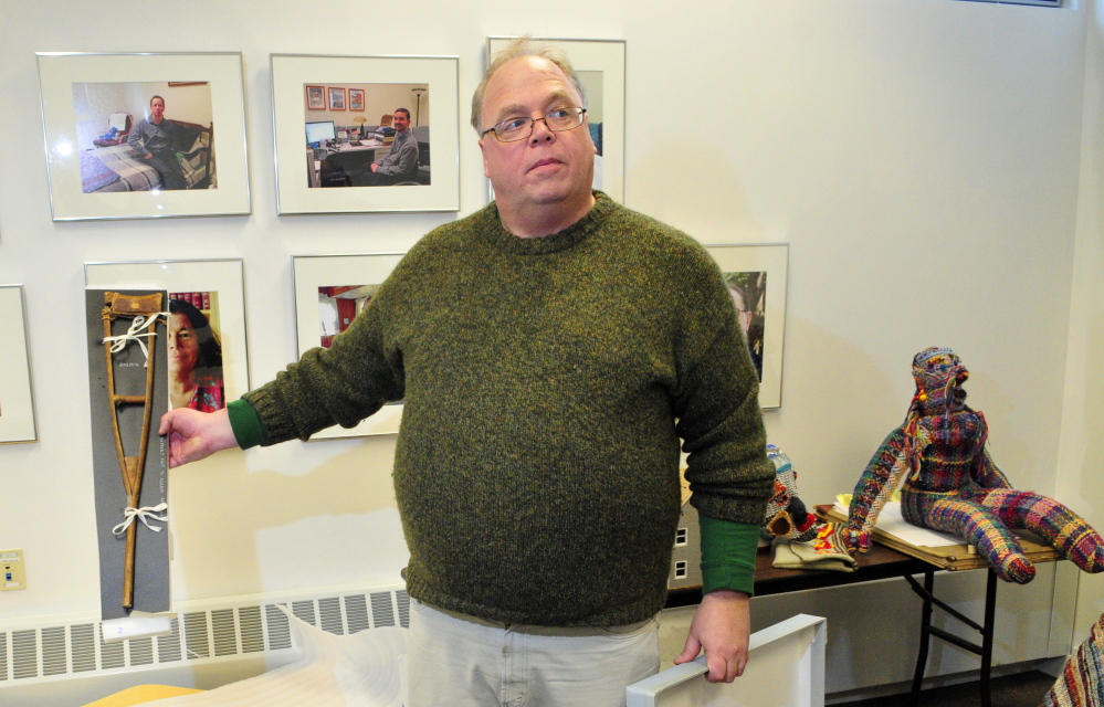 Program director David Greenham shows a wooden crutch on loan from the Maine State Museum while setting up a display at the University of Maine at Augusta that commemorates the 25th anniversary of the signing of the Americans with Disabilities Act.