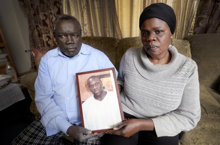 Robert Lobor and Christina Marring hold a photograph of their son Richard Lobor at the family’s home in Portland in December. Richard Lobor died from a gunshot wound in Portland in 2014.