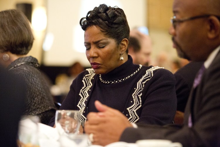 Patricia Malone of Falmouth prays during the annual MLK Jr. Day breakfast hosted by the NAACP at the Holiday Inn by the Bay on Monday in Portland.