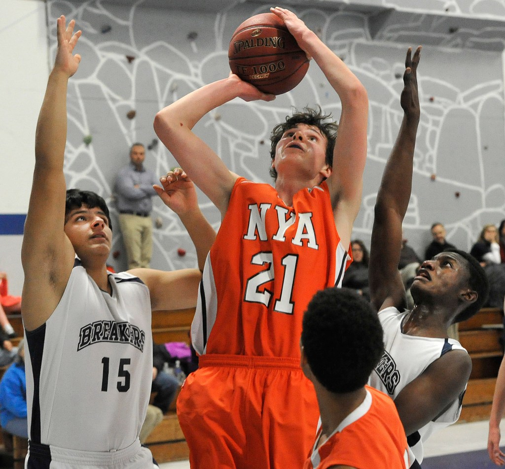 North Yarmouth Academy's Jake Malcom shoots the ball between Pine Tree Academy's Jon Krebs (15) and JP Tshamala during their Jan. 21 contest. NYA won, 42-33.