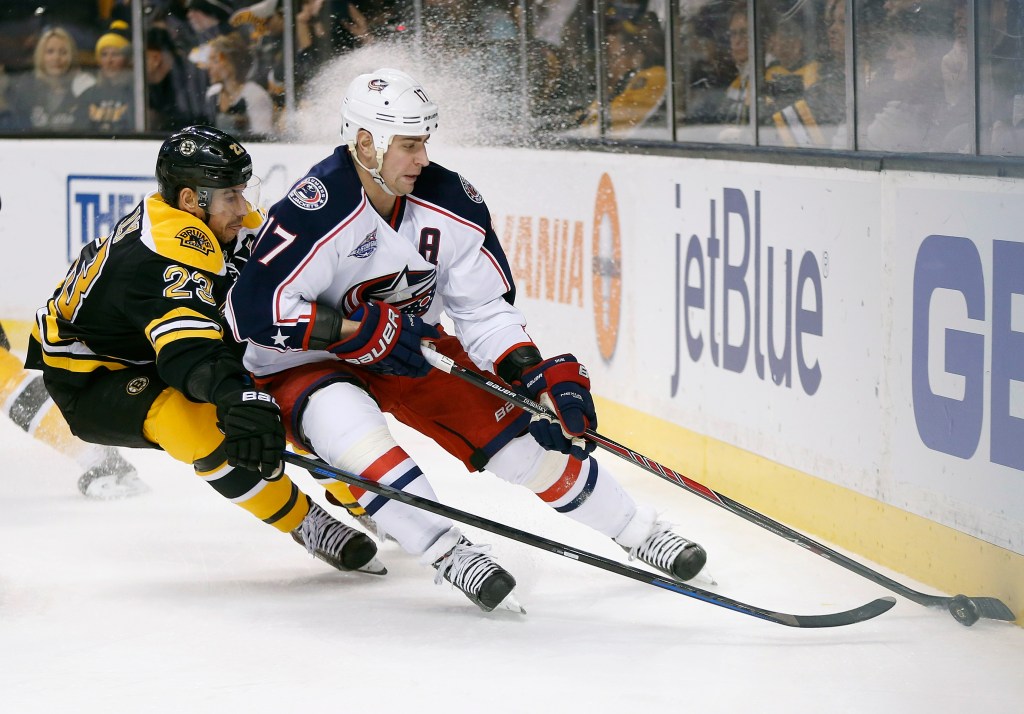 :Boston’s Chris Kelly battles the Blue Jackets’ Brandon Dubinsky for the puck behind the net during Saturday’s game in Boston, won 3-1 by the Blue Jackets. The Associated Press