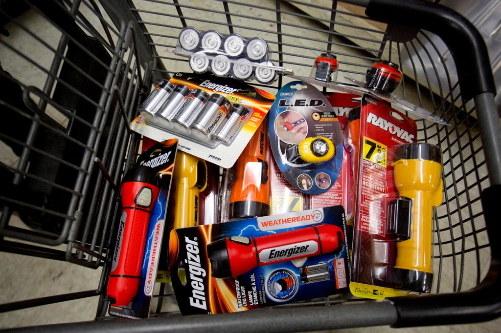 Emily Van Cannon of South Portland filled her cart at Maine Hardware Monday with emergency items in case the power goes out in the approaching storm. 