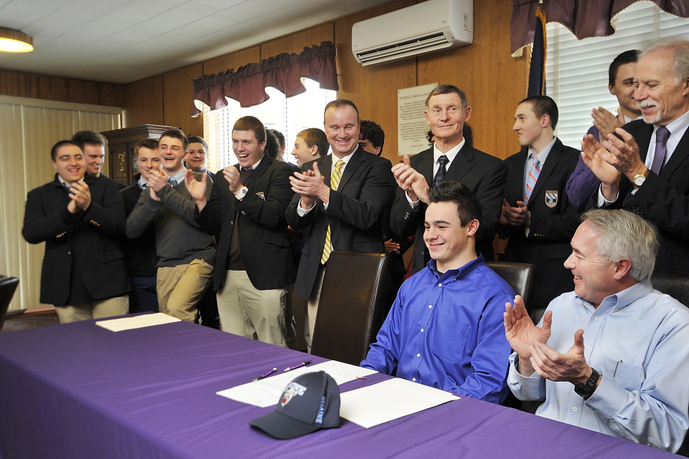 Joe Fitzpatrick is surrounded by family, friends, teammates and the Cheverus staff as he completes the signing of a letter of intent to play football for the University of Maine. Fitzpatrick says he will redshirt next fall.