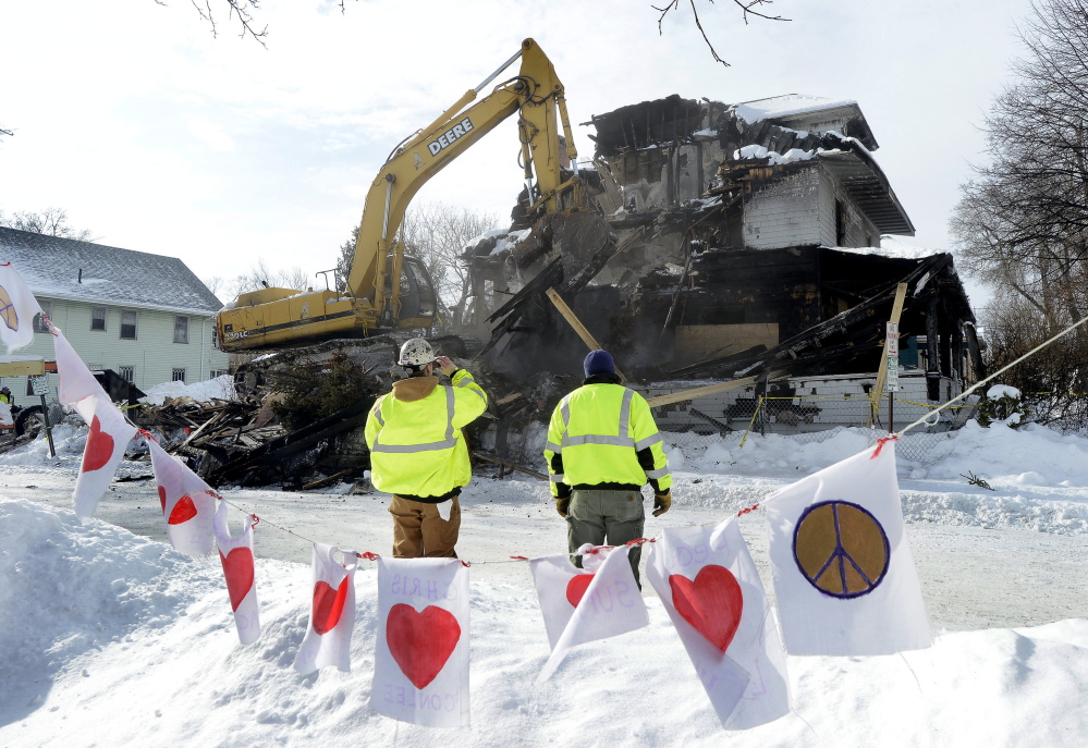 A crew works on demolishing the three-story apartment building at 20-24 Noyes St. in Portland last week, where a Nov. 1 fire killed six young adults. Prosecutors are still weeks away from deciding whether the landlord, Gregory Nisbet, should be charged.