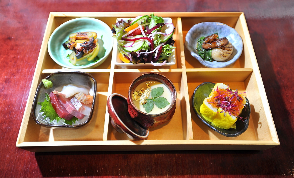 This lunchtime bento box contains, clockwise from top left, braised and seared octopus with kinome miso, fingerling potatoes and pickled fennel; mixed greens salad with miso dressing; foie gras glazed with Japanese honeycomb, confit turnip with hacho miso and wilted spinach; ceviche roll; lobster and matsutake chawanmushi with mitsuba and gold leaf; and bluefin tuna, yellowtail, snapper, salmon toro and fluke sashimi, with a dab of wasabi.