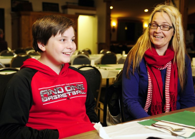 Malachi Walo and his mother, Michelle Hartman, share a laugh Thursday during an interview before an awards presentation honoring Walo’s efforts to save his siblings during a January fire.