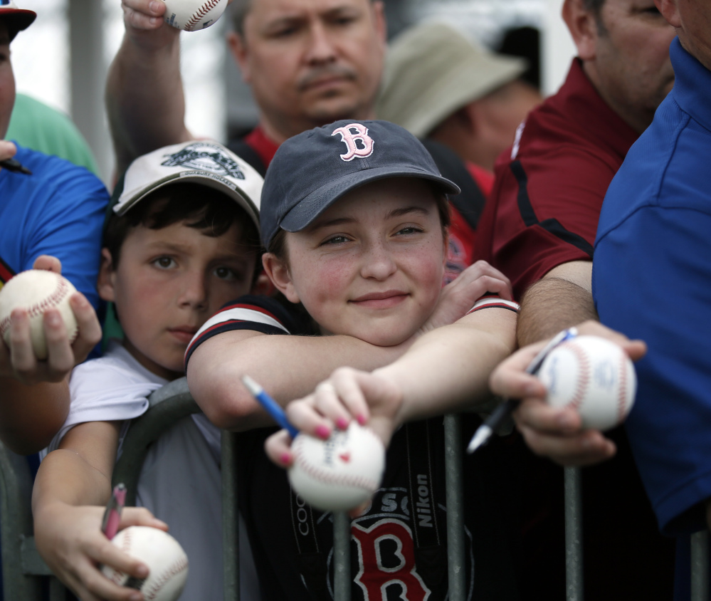 Reece Pearlman of Framingham, Mass., center, smiles as he waits for Mike Napoli to sign an autograph after a workout Monday in Fort Myers. Napoli has reason to smile too after offseason surgery for a severe case of  obstructive sleep apnea.