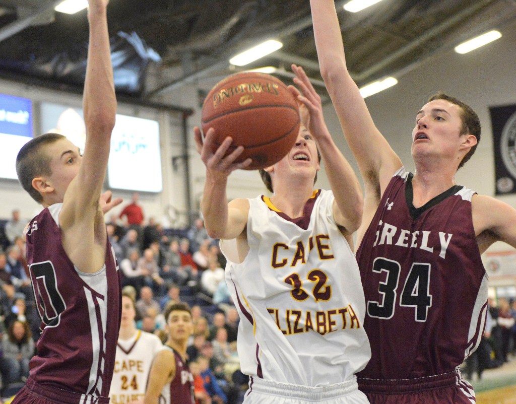 Cape's James Bottomley, 32, slips between Greely defenders Ryan Twitchell, left, and Matt McDevitt  for a layup in Saturday's Western Class B boys' basketball quarterfinal at the Portland Expo. John Ewing/Staff Photographer