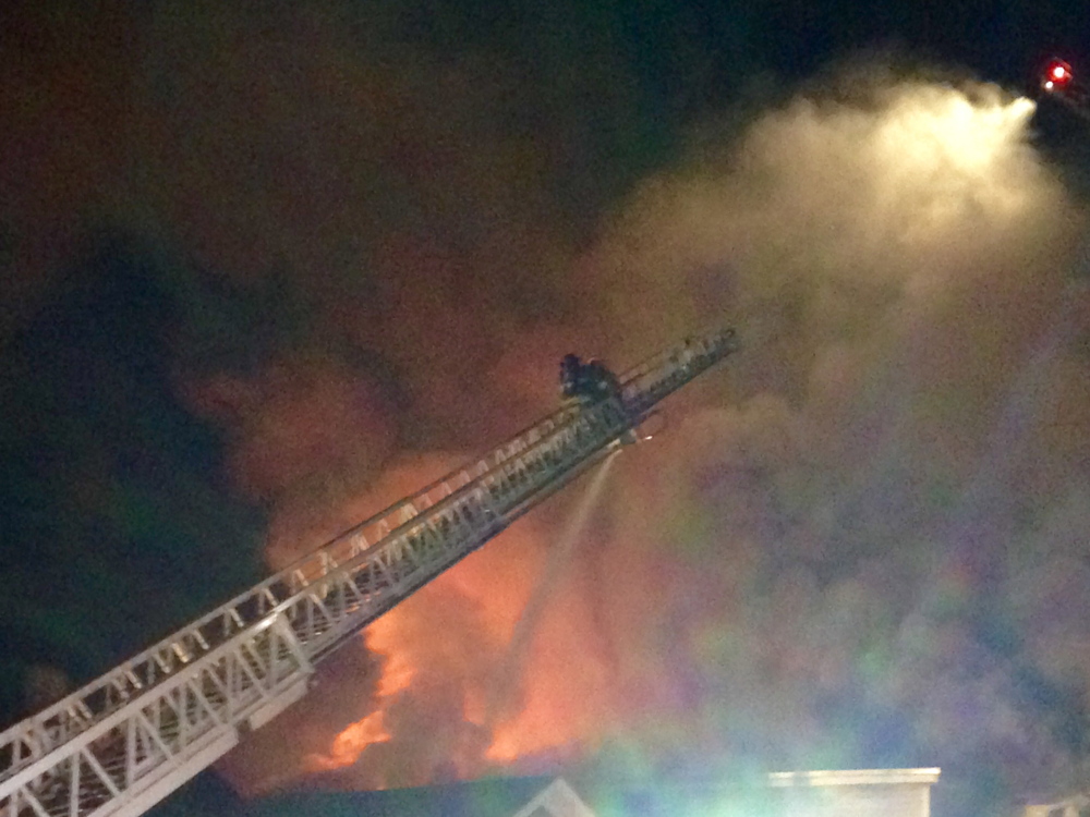 Firefighters pour water on a multi-unit apartment house at 13-15 State St. in Augusta Friday night. Departments from several surrounding communities helped put out the fire, which was reported shortly before 7:30 p.m.