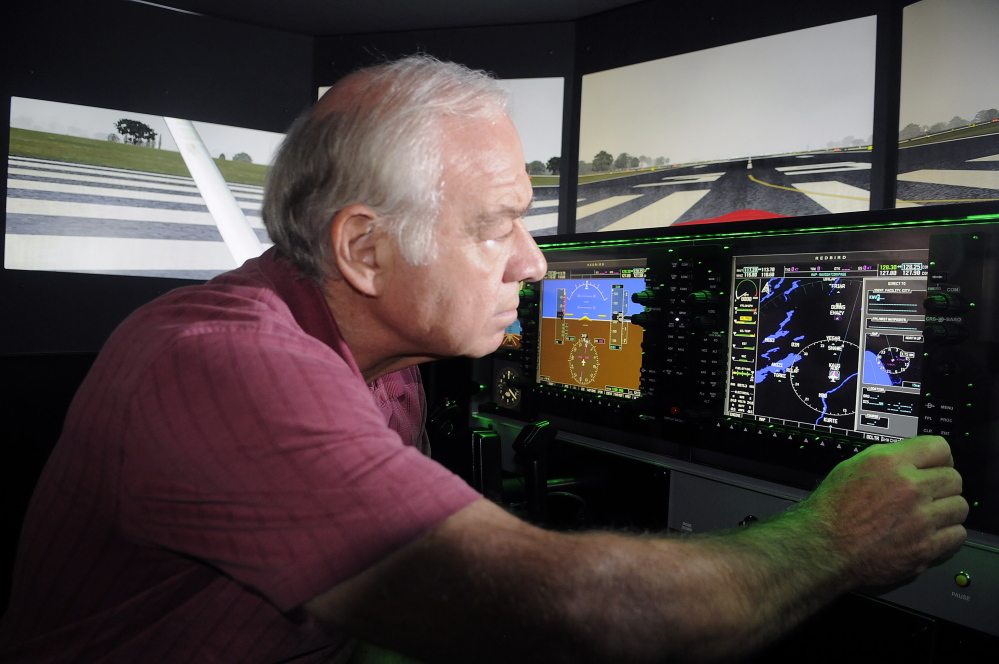 (FILE) University of Maine at Augusta aviation program coordinator Greg Jolda adjusts instruments on the school’s flight simulator. The school announced Tuesday it is expanding its aviation program to Brunswick.