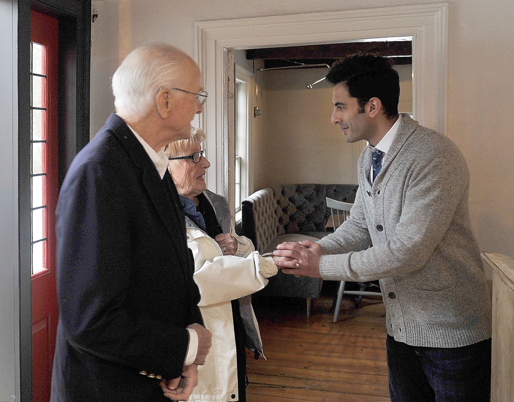 Owner Benjamin Goldman, right, greets two of his first customers, Clyde and Betty Stover of Cape Neddick, at his restaurant’s soft opening at The Velveteen Habit on Wednesday.