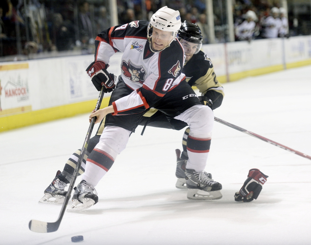 Philip Samuelsson of the Pirates tries to keep the puck away from Dominik Uher of Wilkes-Barre/Scranton during Portland’s 3-1 loss Sunday.