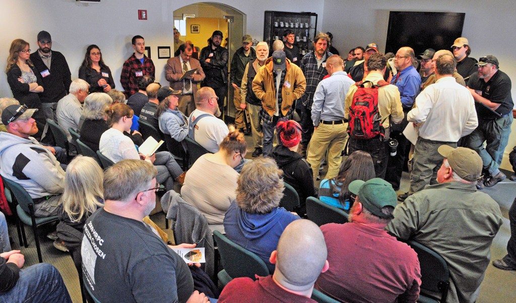 People in the State House Welcome Center listen to Wednesday's committee hearing on gun bills. The fourth-floor committee room was too small to fit everyone who turned out. A smaller group listened in the Hall of Flags.