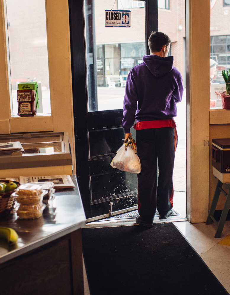 Kevin Segal carries out groceries in a plastic bag at the Hilltop Superette on Monday. Some store owners are surprised how many people are bringing in their own bags.