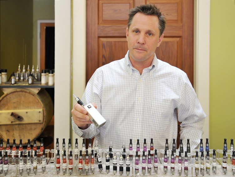 John Kreis, co-owner of the Old Port Vape Shop on Market Street in Portland, shows a vapor device and discusses the benefits of smokers switching to vapor e-cigarettes. Portland may ban e-cigarettes from public spaces.
Gordon Chibroski/ Staff Photographer