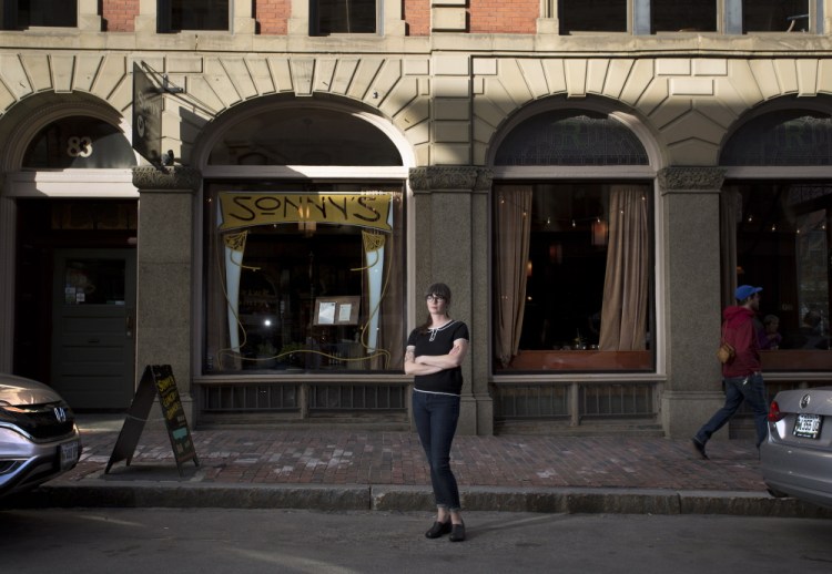 Bar manager Christina Klein stands in an empty parking space outside Sonny’s restaurant on Exchange Street on Thursday. Klein says a proposal by the Portland Bicycle and Pedestrian Advisory Committee to extend the hours for metered parking until 9 p.m. would be detrimental for her employees, many of whom work evenings and park on the street.