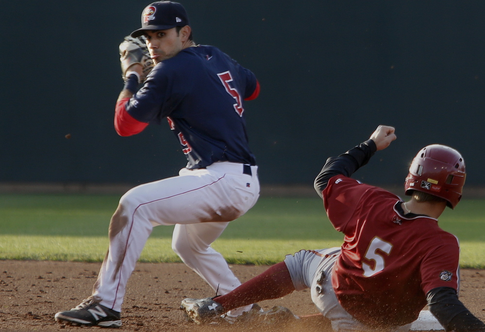 Carlos Asuaje of Portland looks toward first, but holds the ball after forcing out Altoona’s Max Moroff in Tuesday’s game at Hadlock Field. Asuaje went 3 for 5 as the Dogs rallied for a 14-10 win.