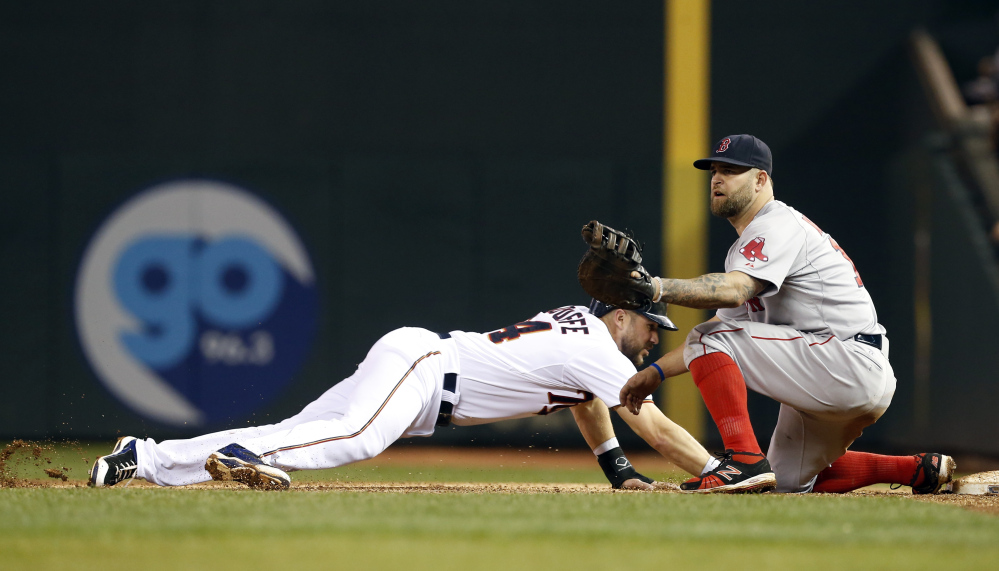 Minnesota Twins’ Trevor Plouffe, left, dives safely back to first on a pick-off attempt by Boston Red Sox first baseman Mike Napoli during the fourth inning of a baseball game, Tuesday, May 26, 2015, in Minneapolis. (AP Photo/Jim Mone)