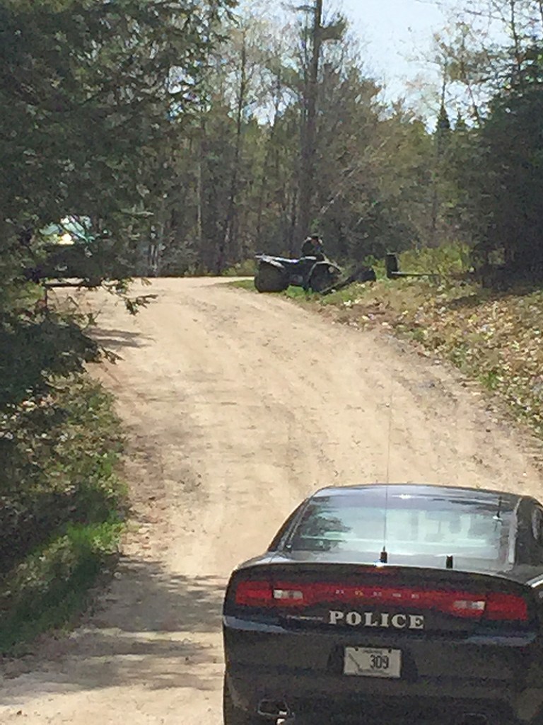 A Maine Game Warden examines an ATV that crashed on Miles Way in Freeport Friday morning. Photo by David Hench / Staff Writer