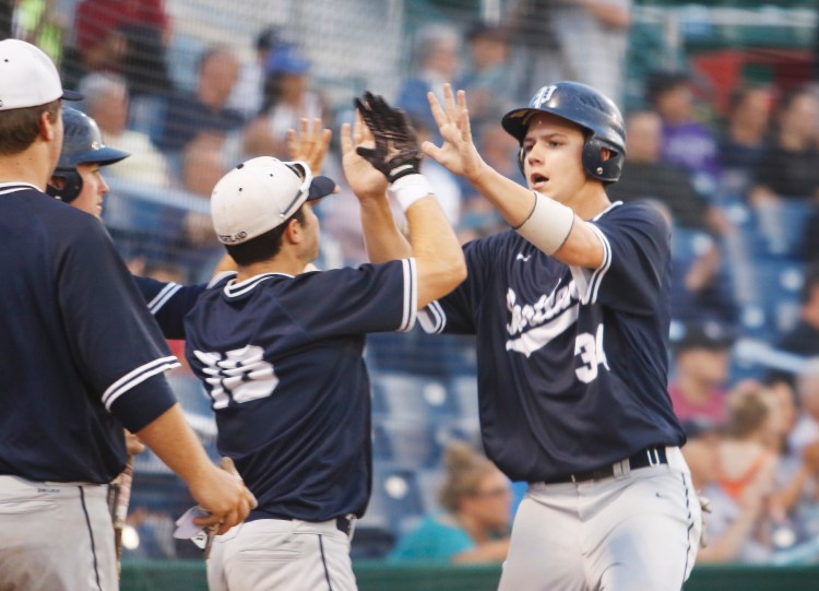 Zach Fortin, right, of Portland is greeted by George Chaison-Lapine after scoring during the four-run fifth inning that made the difference against Deering. Portland will meet Falmouth in the semifinals at 1 p.m. Saturday at Hadlock.
Jill Brady/Staff Photographer