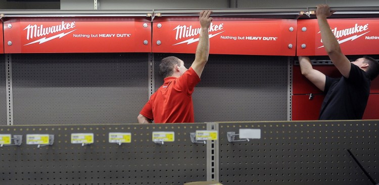 Vendors hang a tool display at Randolph Hardware on Tuesday in Randolph.